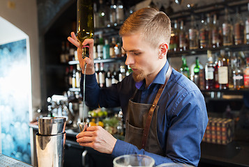 Image showing barman with shaker preparing cocktail at bar