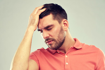 Image showing unhappy man suffering from head ache