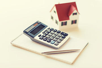 Image showing close up of home model, calculator and notebook