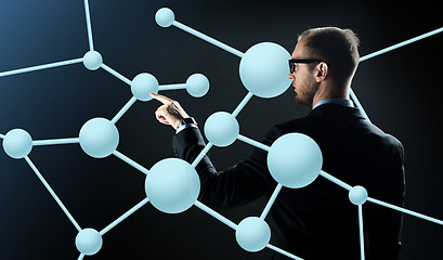 Image showing businessman pointing finger to virtual molecule