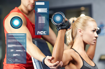 Image showing man and woman with dumbbells in gym