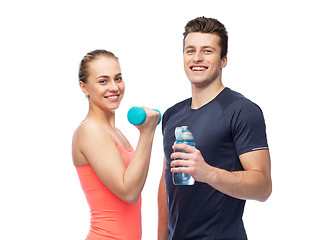 Image showing sportive man and woman with dumbbell and water