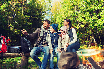 Image showing family with smartphone taking selfie near campfire