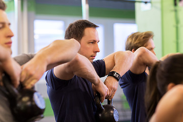 Image showing group of people with kettlebells exercising in gym