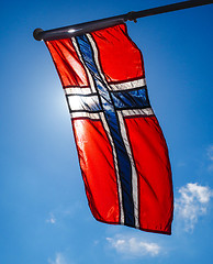 Image showing Norwegian flag up close, towards the sun on beautiful blue sky