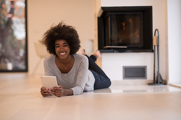 Image showing black women using tablet computer on the floor