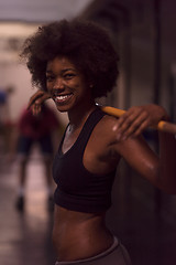 Image showing black woman lifting empty bar