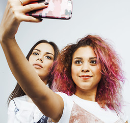 Image showing lifestyle people concept: two pretty stylish modern hipster teen girl having fun together, diverse nation mixed races, happy smiling making selfie 