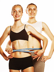 Image showing two sport girls measuring themselves isolated on white