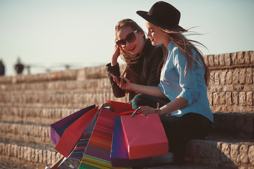 Image showing Two girls walking with shopping on city streets