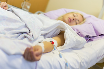 Image showing Bedridden female patient recovering after surgery in hospital care.