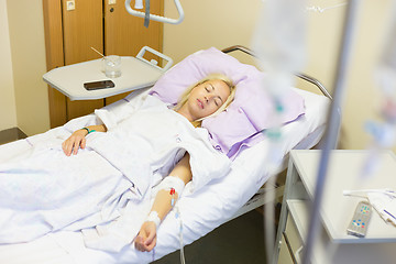 Image showing Bedridden female patient recovering after surgery in hospital care.