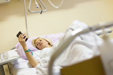 Image showing Bedridden female patient recovering after surgery in hospital care.