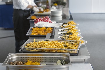 Image showing French fries and meat on the table