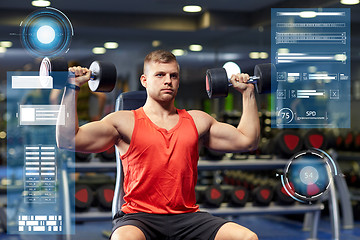 Image showing young man with dumbbells flexing muscles in gym