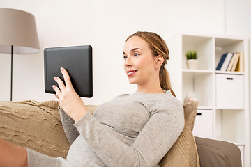 Image showing happy pregnant woman with tablet pc at home