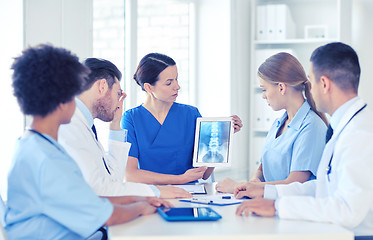 Image showing group of doctors with x-ray on tablet pc at clinic