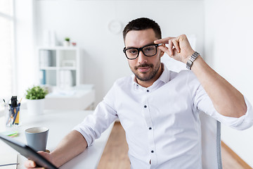 Image showing businessman in glasses with tablet pc at office