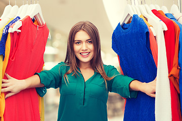 Image showing happy woman choosing clothes at home wardrobe