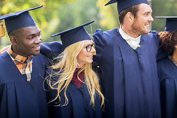 Image showing happy students or bachelors in mortar boards