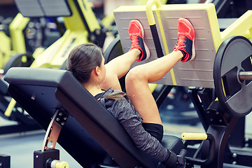 Image showing woman flexing muscles on leg press machine in gym