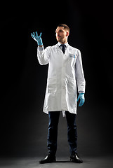 Image showing doctor or scientist in lab coat and medical gloves