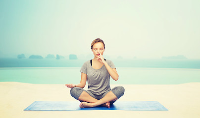 Image showing woman making yoga meditation in lotus pose on mat