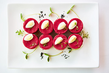 Image showing layered salad with herring, beets, carrots, onions, potatoes and eggs close-up on a plate. horizontal.