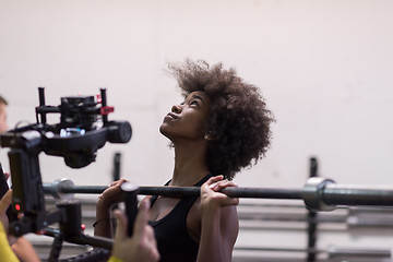 Image showing black woman lifting empty bar