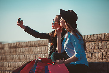 Image showing Two girls walking with shopping on city streets