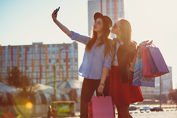 Image showing Two girls walking with shopping on city streets