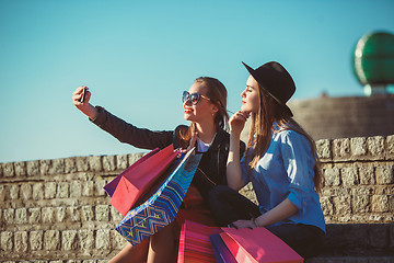 Image showing Two girls walking with shopping on city streets