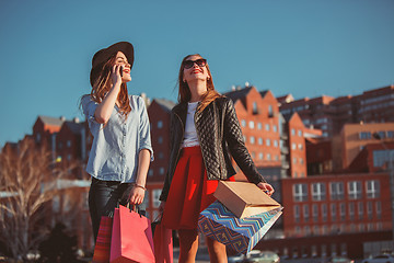 Image showing Two girls walking with shopping on city streets