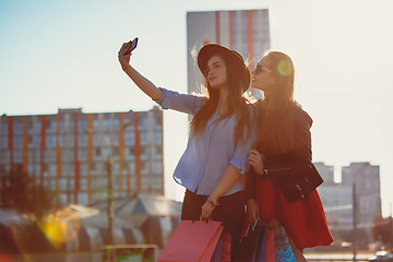 Image showing Two girls walking with shopping on city streets