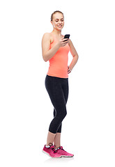 Image showing happy smiling sportive young woman with smartphone