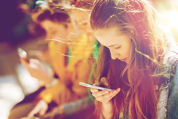 Image showing happy teenage friends with smartphones outdoors