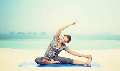 Image showing happy woman making yoga and stretching on mat