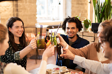 Image showing happy friends with drinks at bar or cafe