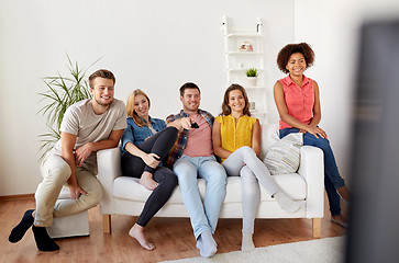 Image showing happy friends with remote watching tv at home