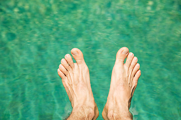 Image showing male feet over sea water