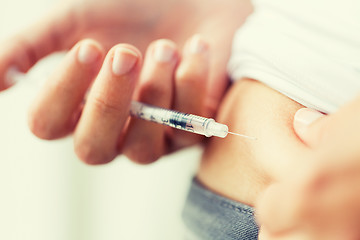 Image showing woman with syringe making insulin injection