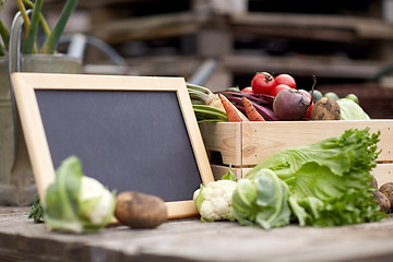 Image showing close up of vegetables with chalkboard on farm