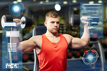 Image showing young man with dumbbells flexing muscles in gym