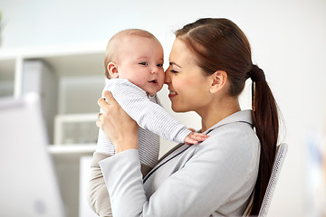 Image showing happy businesswoman with baby at office