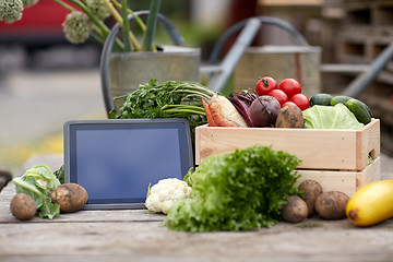 Image showing close up of vegetables with tablet pc on farm