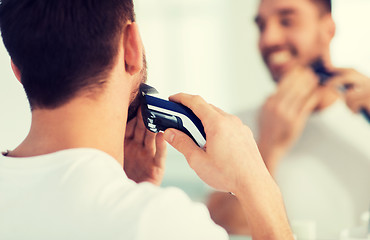 Image showing close up of man shaving beard with trimmer