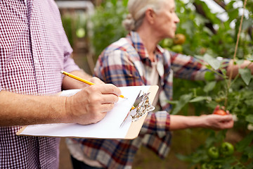 Image showing senior couple with clipboard at farm