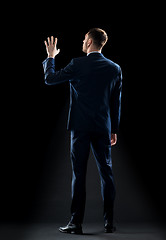 Image showing businessman in suit touching something invisible