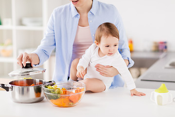 Image showing happy mother and baby cooking vegetables at home