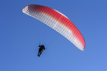 Image showing Paraglider flying in the blue sky as background